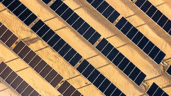 Photo depicts aerial Sunrise View over Solar Panels in Palm Springs California